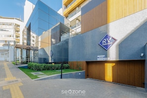A modern building with a glass facade, a wooden panel section, and a sign indicating RV Concessio. - Apartments in a Building With a Pool 800m From the Beach in Salvador - EDF (Salvador)
