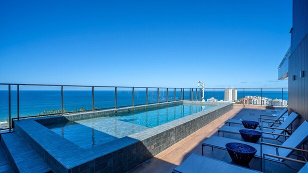 A rooftop infinity pool with a clear view of the ocean and city skyline. - Apartments in a Building With a Pool 800m From the Beach in Salvador - EDF (Salvador)
