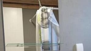Un bagno con un lavabo a incasso bianco, uno specchio sopra e un asciugamano sul ripiano.