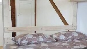 Un letto a castello con struttura in legno e copripiumino fantasia.
