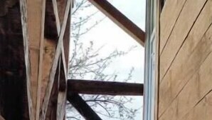 A wooden staircase leading to a covered area with a view of trees outside. - White Bosnian pyramid glamping (Visoko)