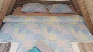 Un letto con una coperta a quadri e cuscini.