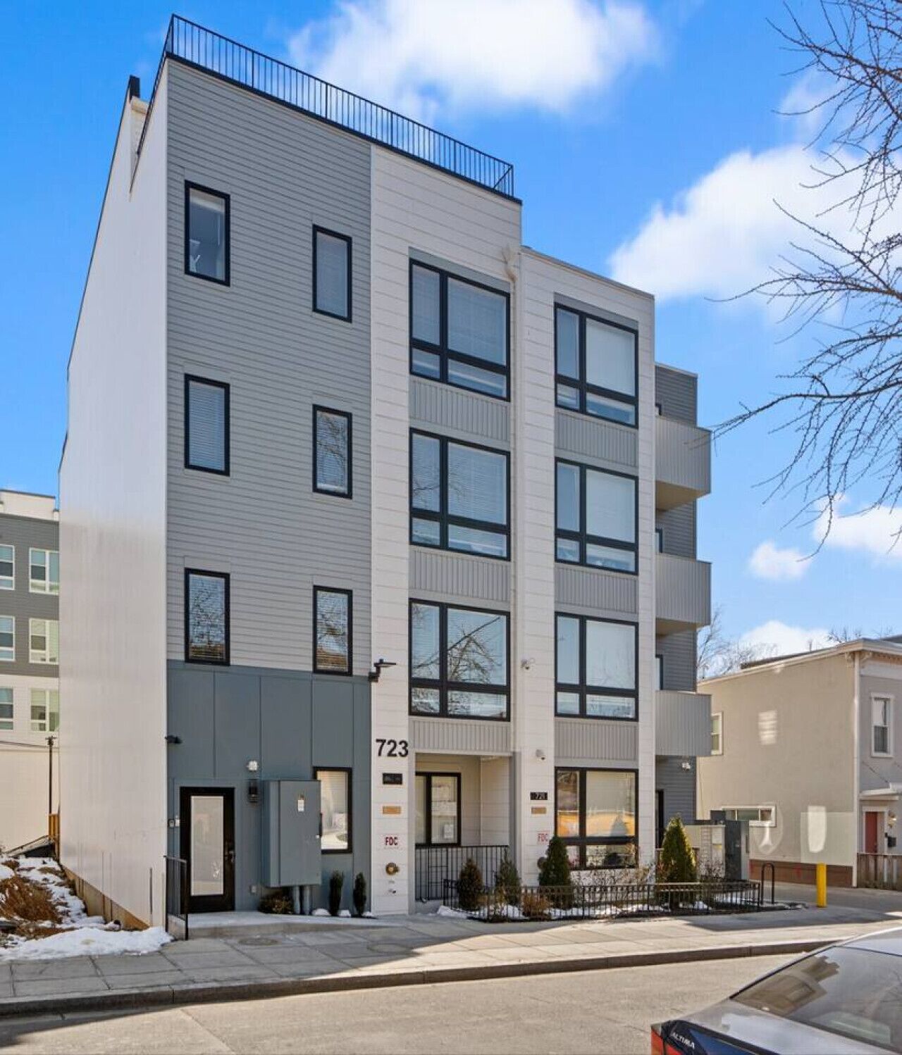 A multi-story residential building with a modern design, featuring large windows and balconies.