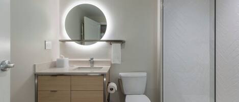 A modern bathroom with a toilet, sink, and shower.
