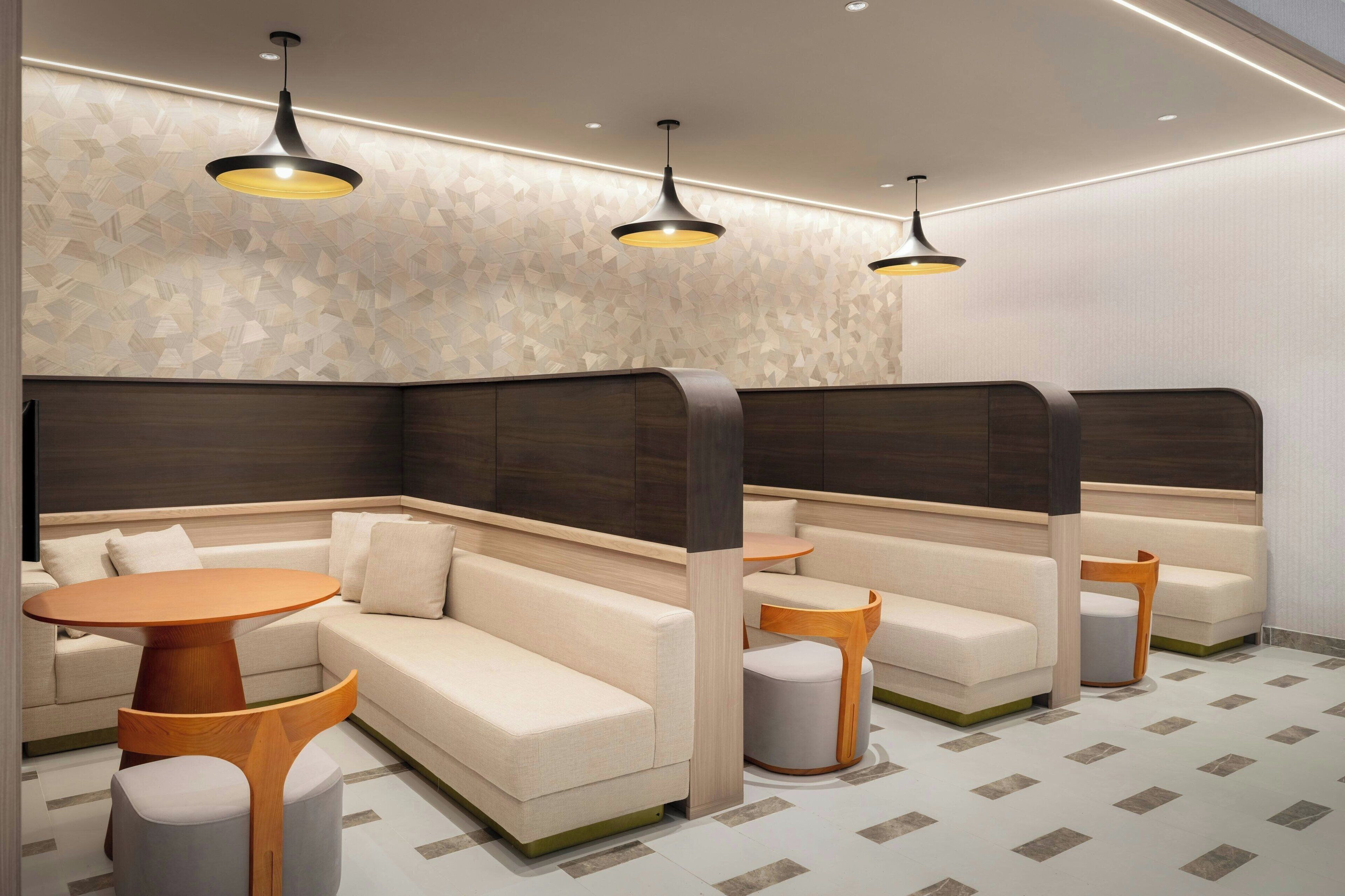 Un espace de détente moderne comprenant un canapé, une table ronde et un petit tabouret.