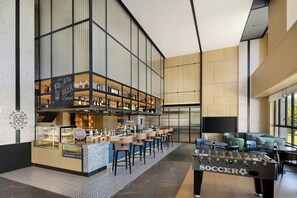 A modern bar area with a foosball table, bar stools, and shelves of bottles. - Four Points By Sheraton Ji’An (Ji'an)