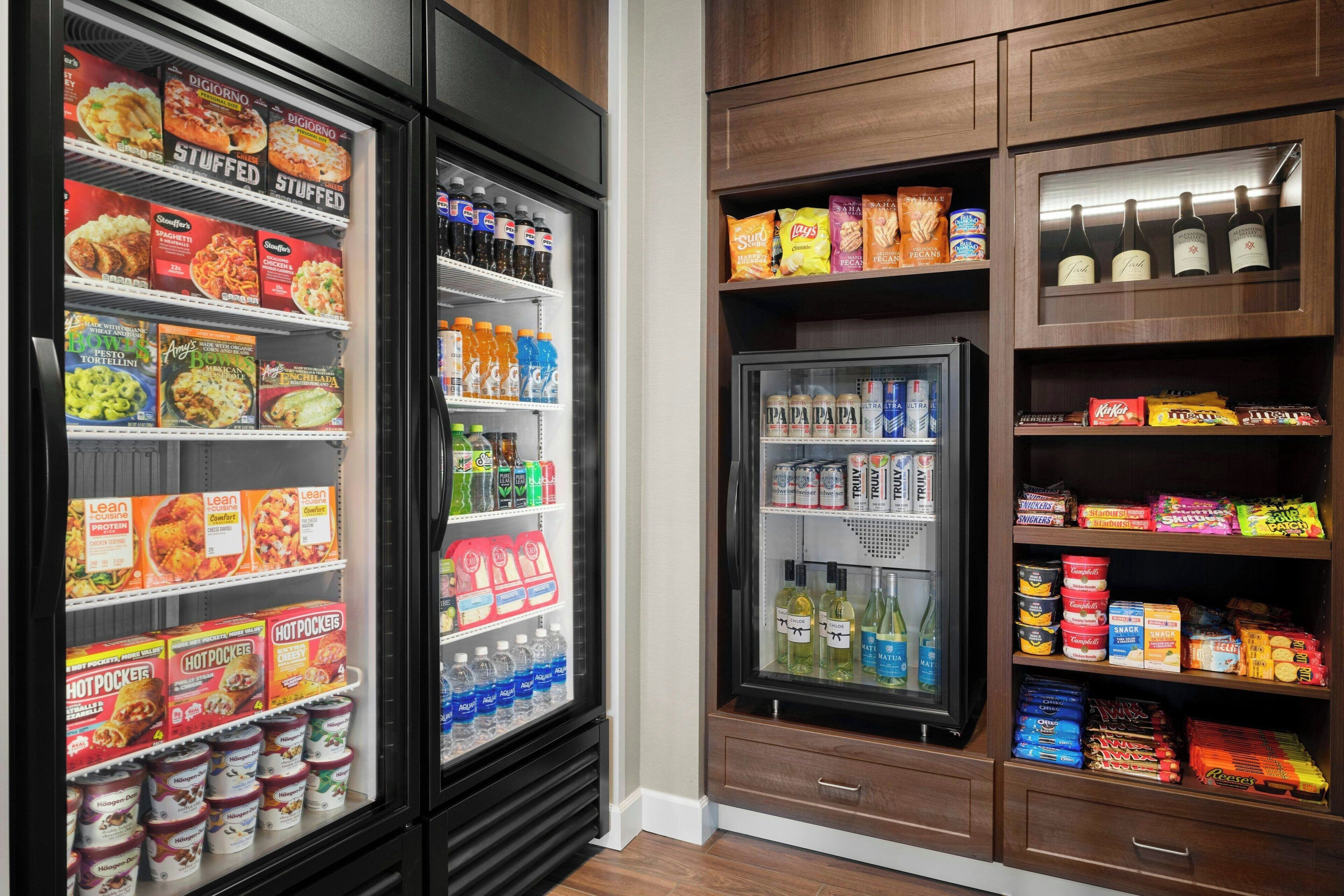 A refrigerated display with various food items and beverages, including boxed meals, hot beverages, and snacks.
