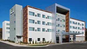 A modern hotel building with a prominent entrance, multiple floors, and a clear sky.