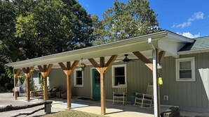 A covered porch with wooden beams, a green door, and a window with the number 5715. - Escape to Comfort in Newport (Newport)