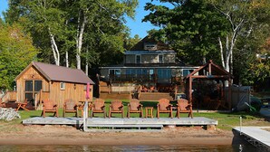 A lakeside cabin with a dock, wooden deck, and outdoor seating area. - Polar Bear Cabin at The Bears Cottages (Inlet)