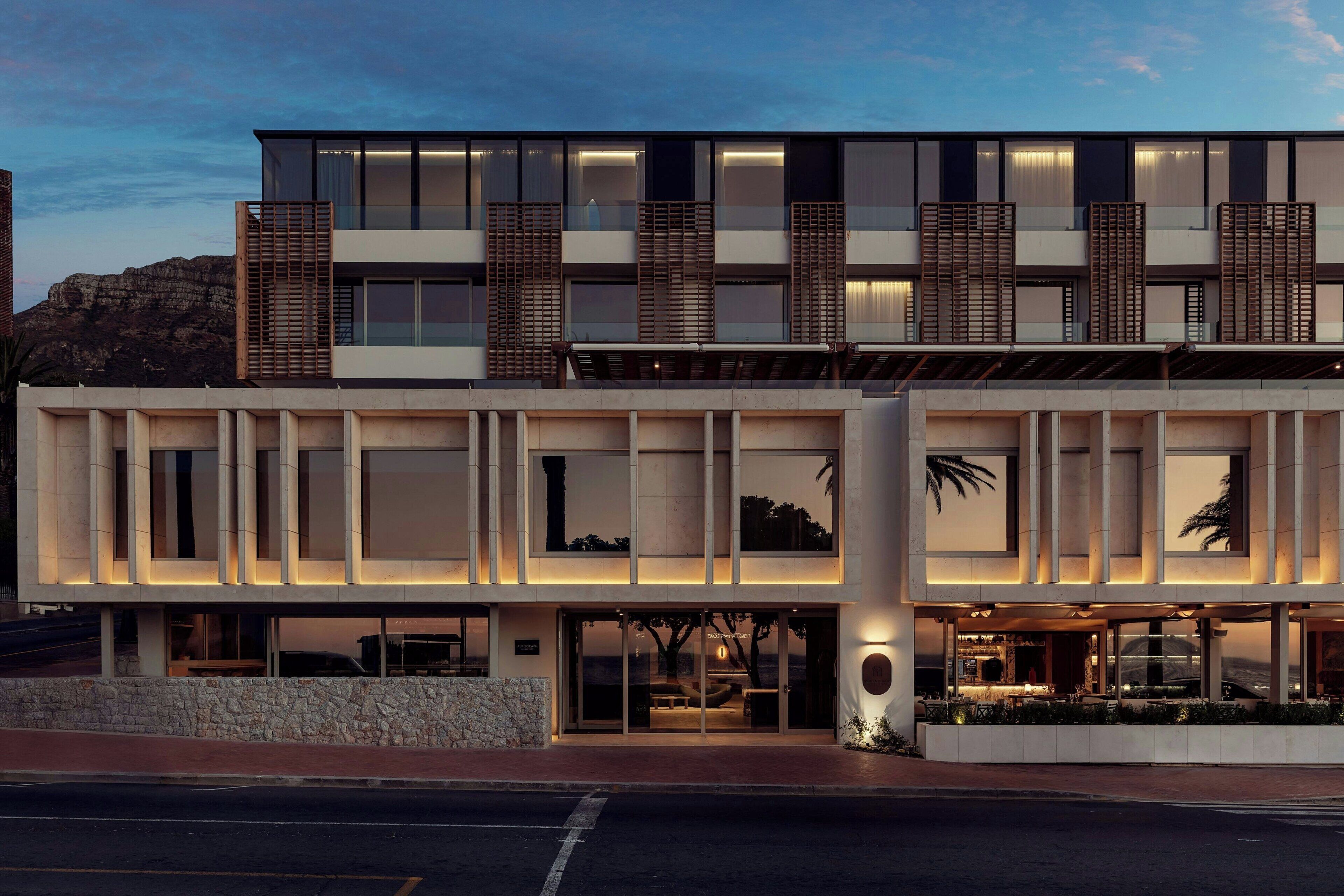 A modern hotel with a two-story structure, large windows, and a stone facade.