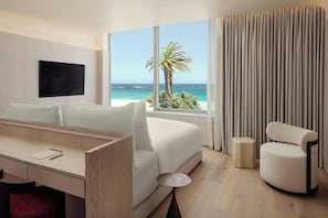 Una habitación de hotel con una cama, un escritorio, una silla y un televisor.