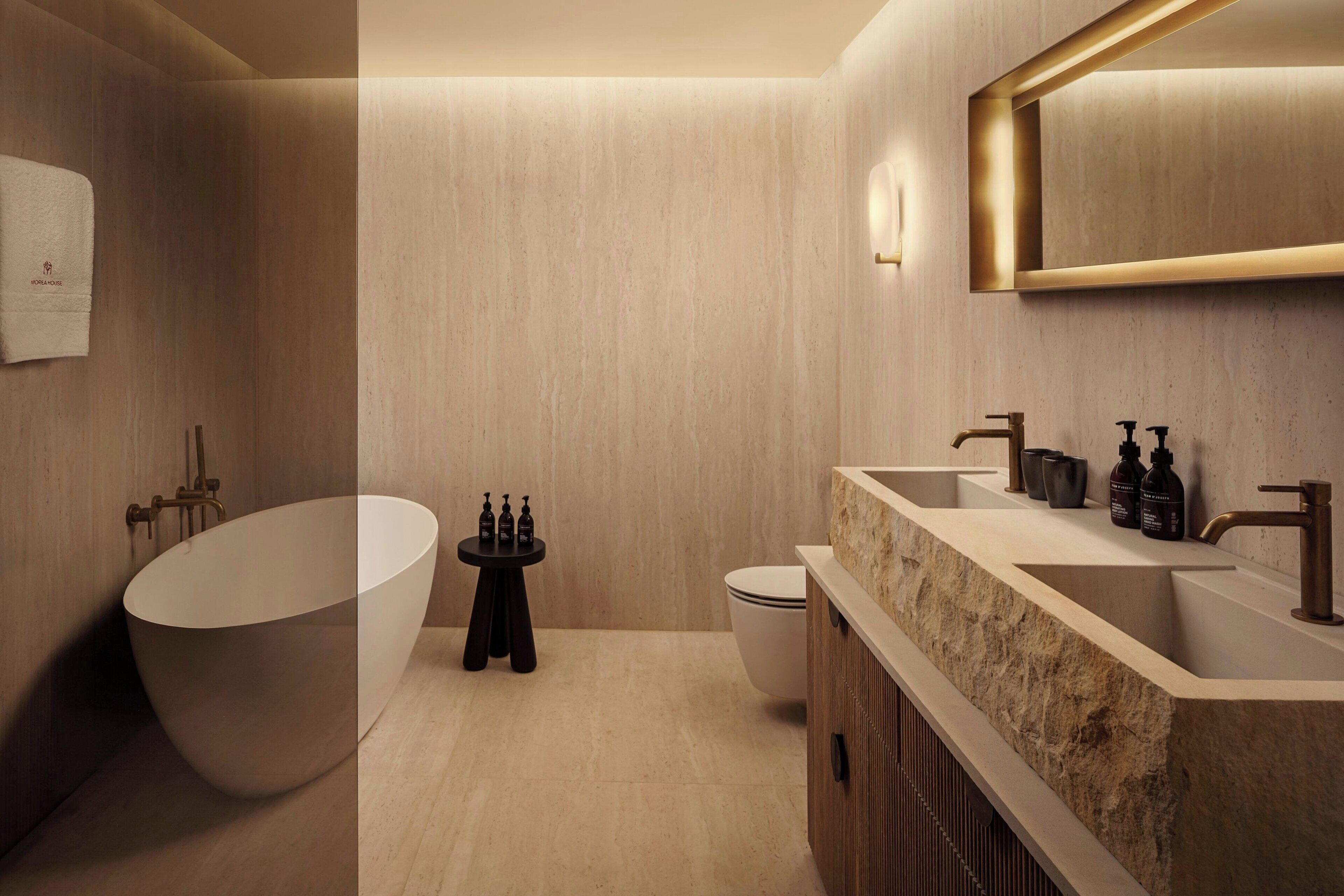 A modern bathroom with a freestanding bathtub, a vanity with a sink, and a toilet.