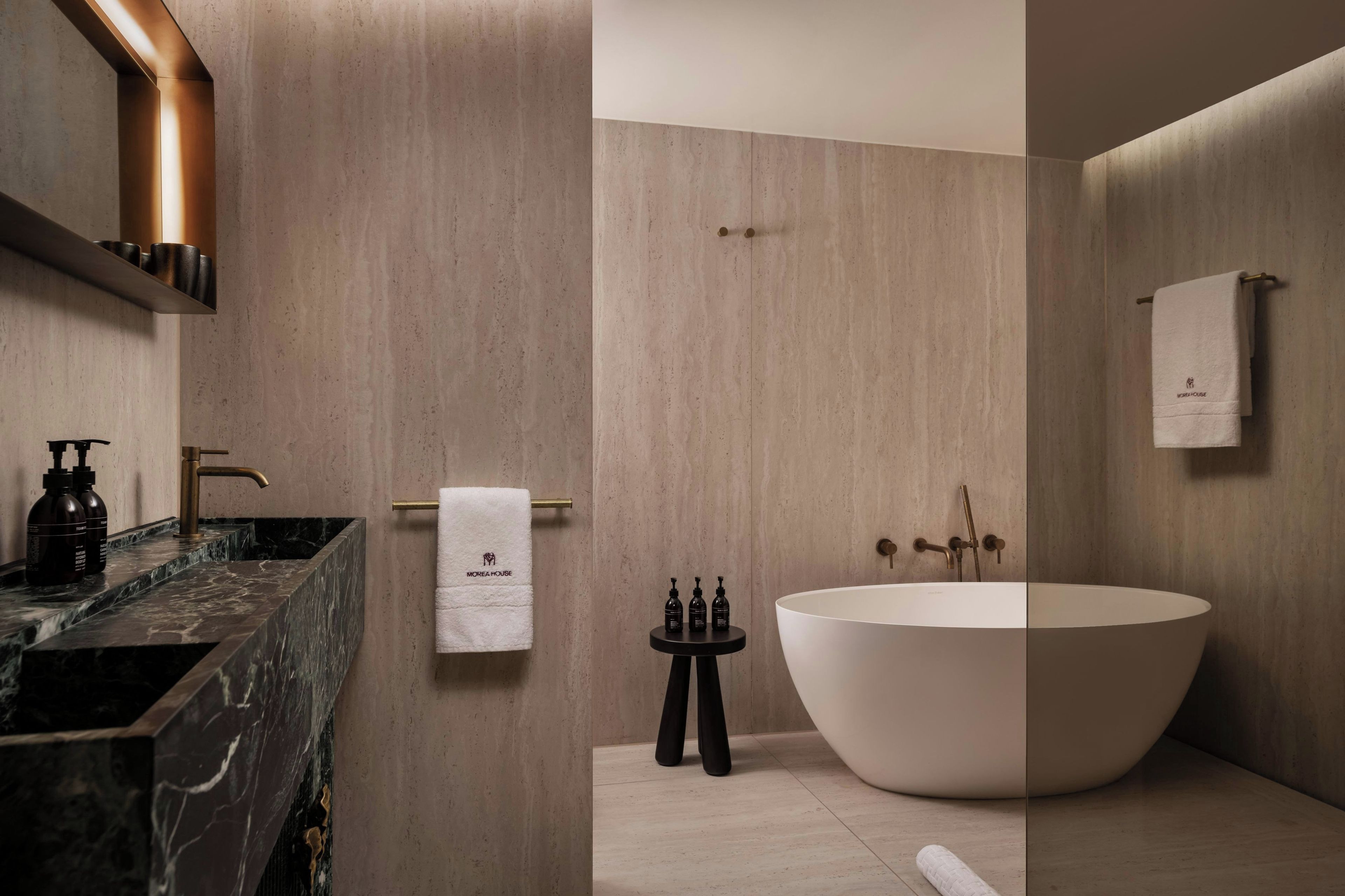A modern bathroom with a freestanding bathtub, a marble countertop, and a towel rack.