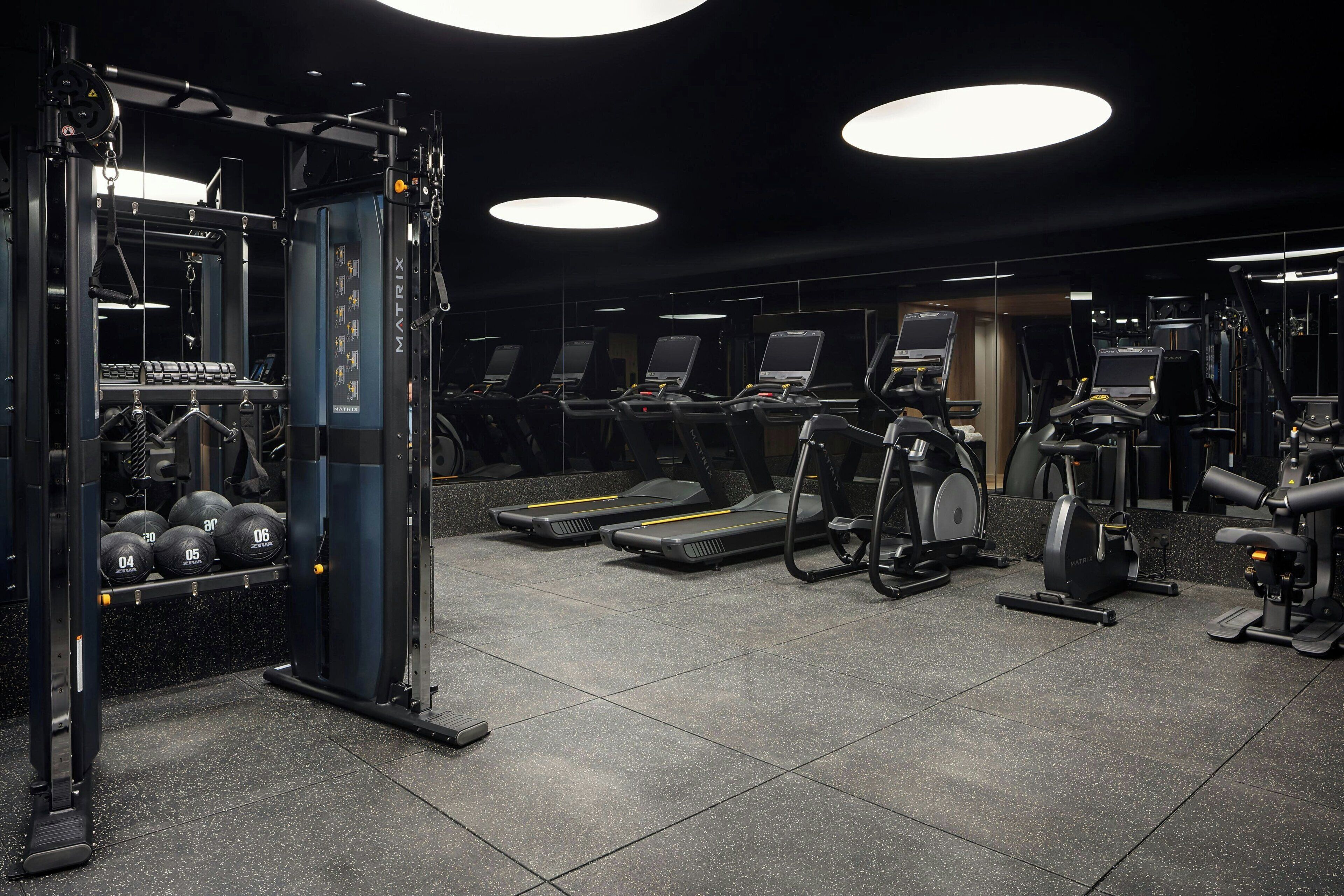 A gym with treadmills, elliptical machines, and weightlifting equipment.
