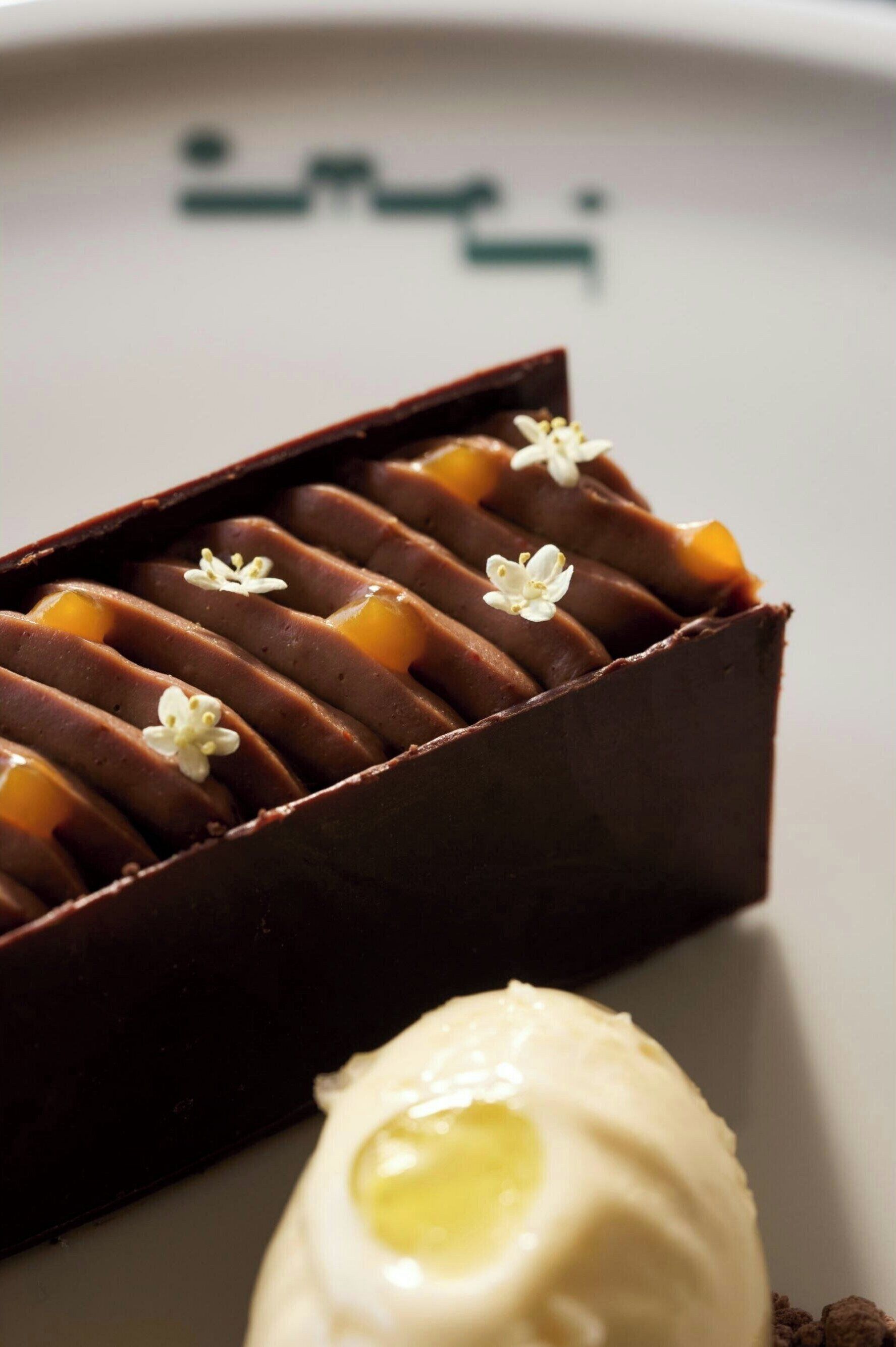 Un dessert au chocolat accompagné d’une quenelle de crème blanche.