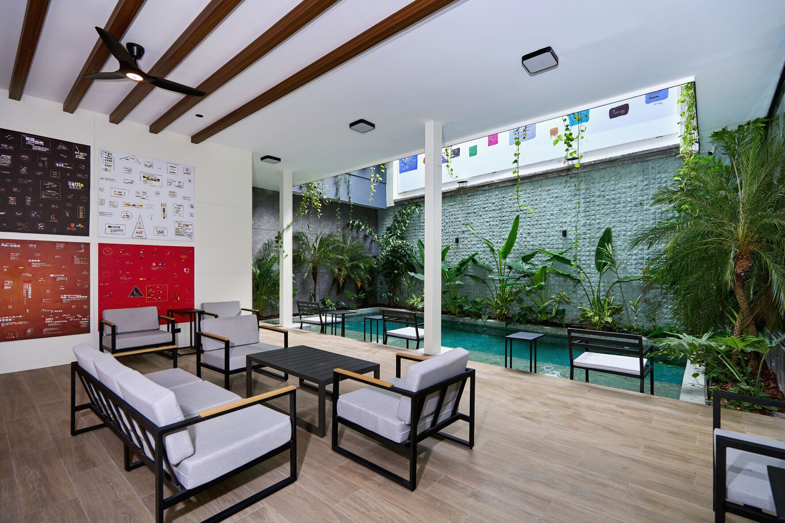 Un espace piscine intérieur moderne, doté de sièges et offrant une vue sur un mur végétal.