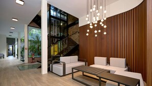 A modern lobby with a staircase, seating area, and a hanging light fixture. - Exclusively designed room CG15 (Ciudad de Panamá)