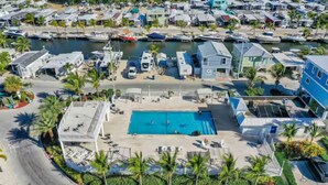 An aerial view of a coastal residential area with a swimming pool, boats, and houses. - Charming 2-bedroom campground in Key Largo with AC (Key Largo)