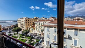 Un paysage urbain côtier avec des bâtiments, une rue et une vue sur la mer.