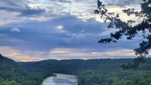A river winding through a densely forested valley with a backdrop of hills and a cloudy sky. - Romantic GLAMPING w Vista Views of WHITE RIVER (Cotter)