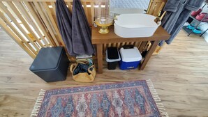 A compact kitchenette with a wooden table, a sink, a glass container, and storage boxes. - Romantic GLAMPING w Vista Views of WHITE RIVER (Cotter)