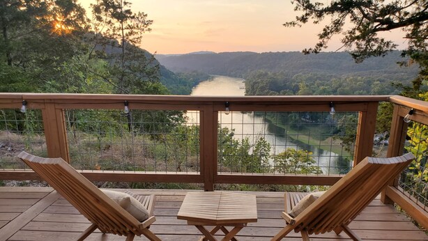 A wooden deck with two lounge chairs and a small table, overlooking a river and forested hills. - Romantic GLAMPING w Vista Views of WHITE RIVER (Cotter)