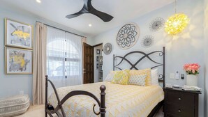 A bedroom with a bed, bedside table, and decorative wall art.