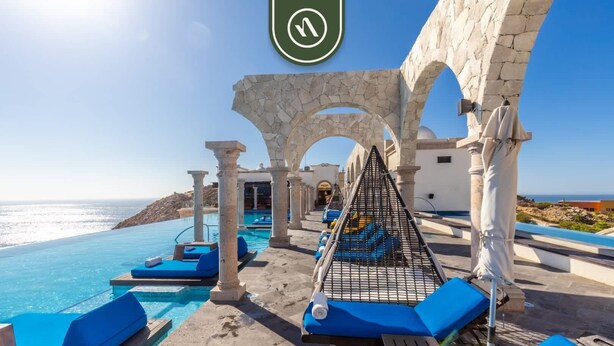 A poolside area with blue lounge chairs, a hammock, and a view of the sea. - Marvelous Villa with Private Pool & Patio in Cabo (Cabo San Lucas)