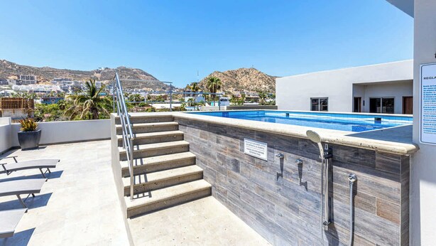 A rooftop pool with a view of a cityscape and mountains. - Centric Apt in Downtown - Rooftop Pool - Terrace (Cabo San Lucas)