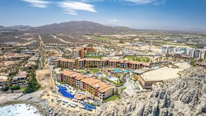 Et resort med flere bygninger, en swimmingpool og en strand.