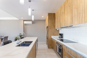 Una cocina moderna con armarios de madera, una isla central con pileta y horno integrado.