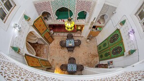 A traditional interior with a central seating area, ornate wall decorations, and a patterned floor. - RIAD MOHAMADIA (Fes)