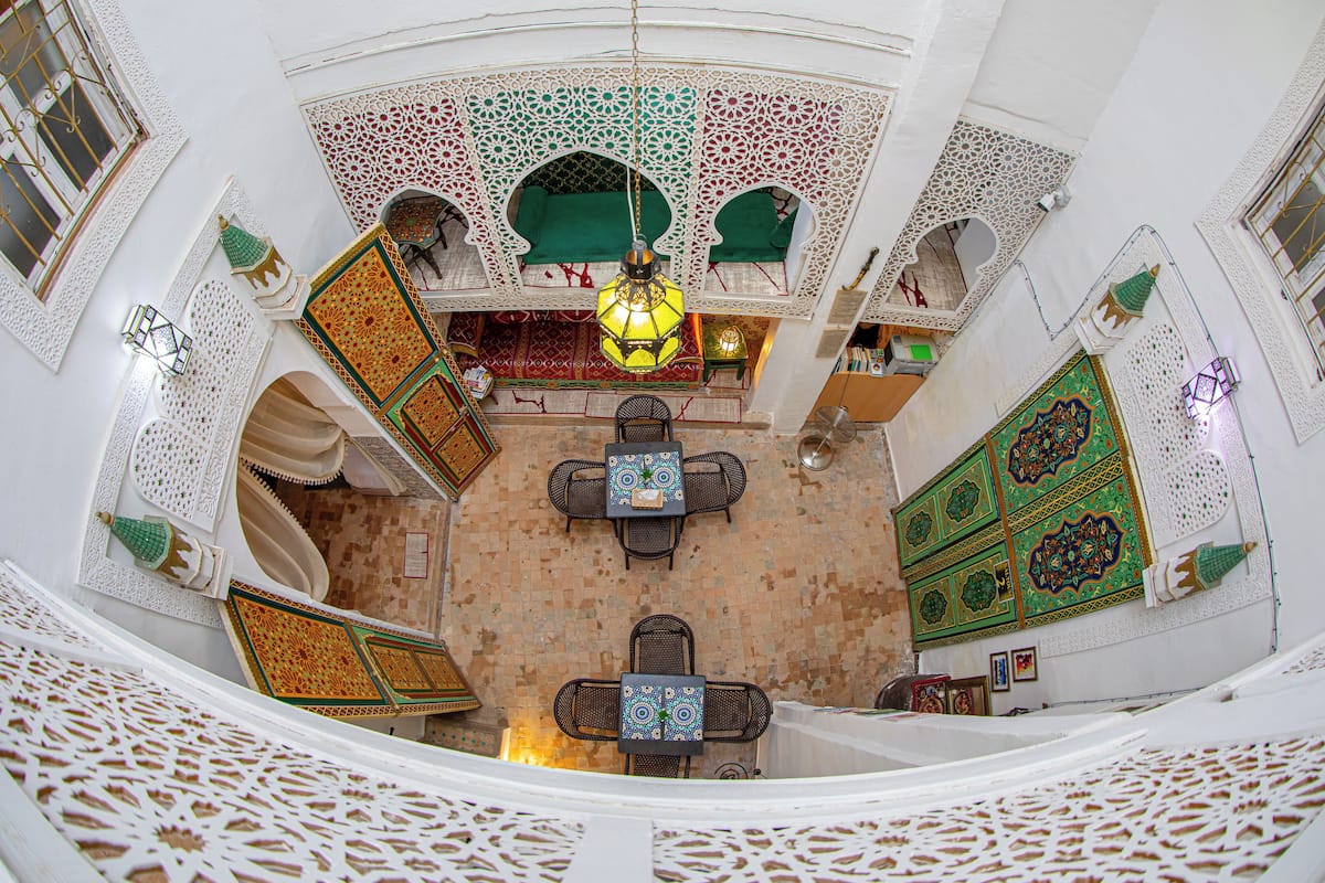 A traditional interior with a central seating area, ornate wall decorations, and a patterned floor.