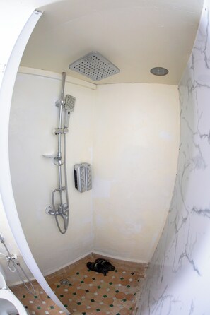 Habitación triple Confort, vista al patio | Baño | Regadera, toallas, jabón, shampoo 