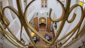 A courtyard with a central fountain, surrounded by white walls and intricate lattice work. - RIAD MOHAMADIA (Fes)