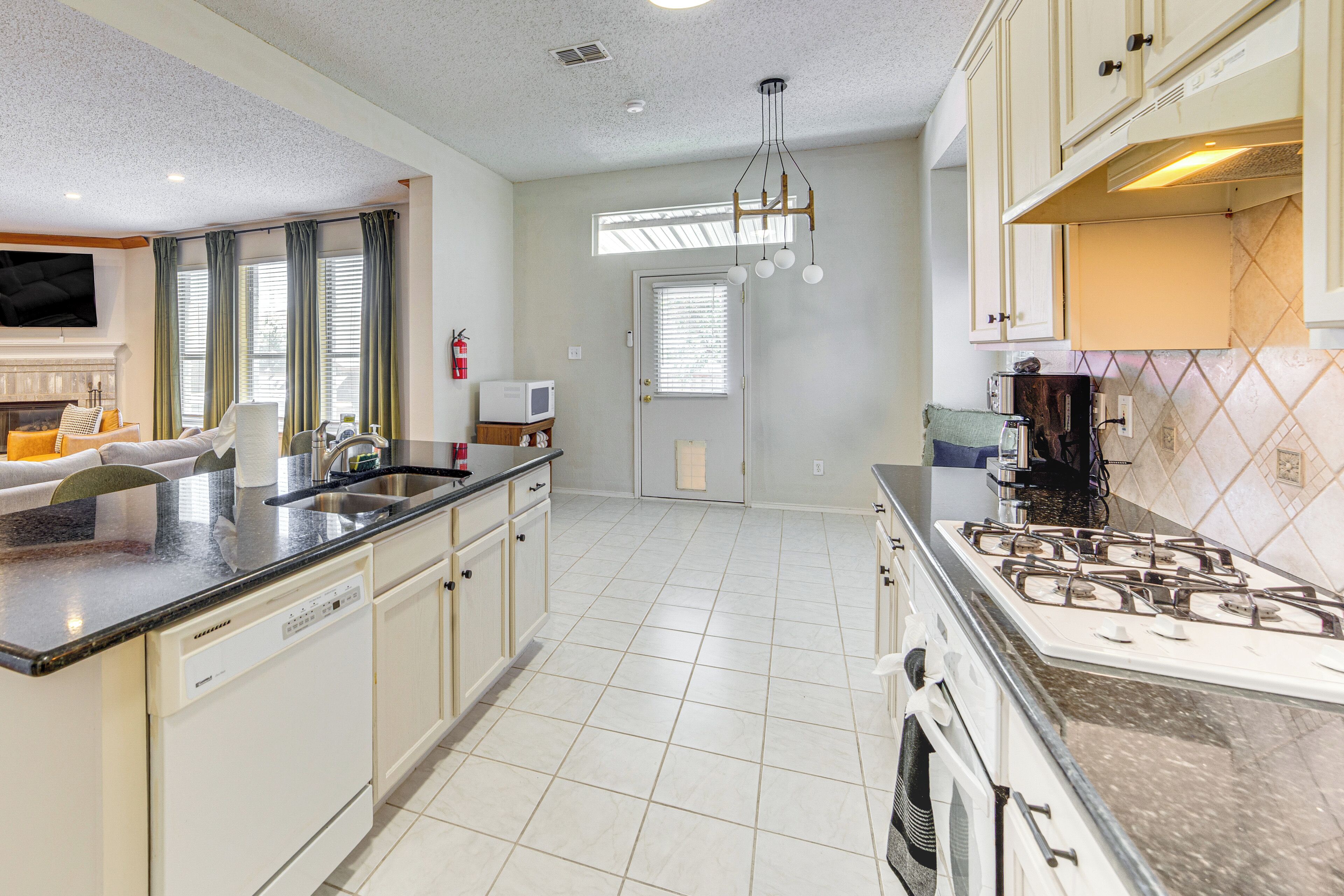 A modern kitchen with a dishwasher, stove, and a large island with a sink.