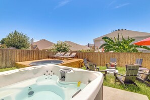 A backyard with a hot tub, lounge chairs, and a wooden deck. - Group-Friendly Grand Prairie Home w/ Perks! (Grand Prairie)