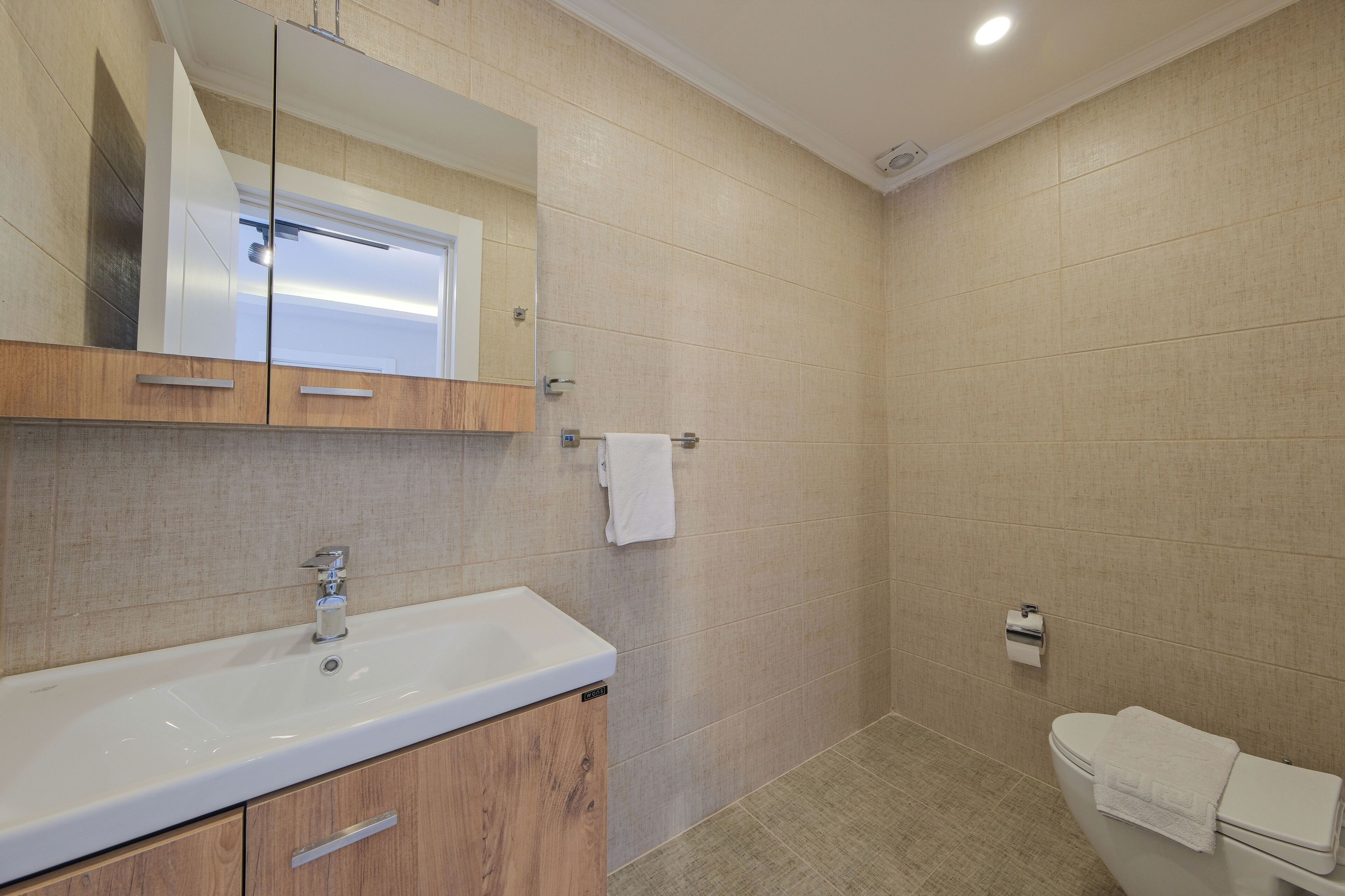 A bathroom with a sink, mirror, and toilet.