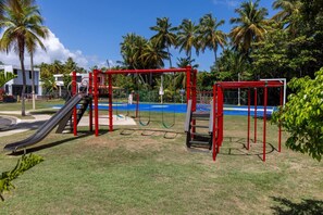 A playground with a slide and swings.