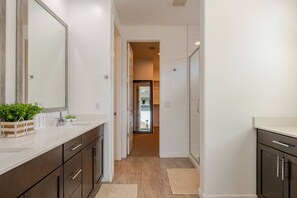 A modern bathroom with a large mirror, a sink, and a cabinet.
