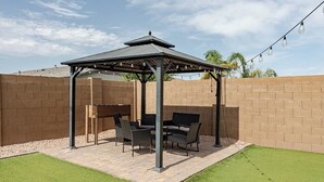 A patio with a pergola, outdoor furniture, and a string of lights. - Luxurious Arizona Retreat (Queen Creek)