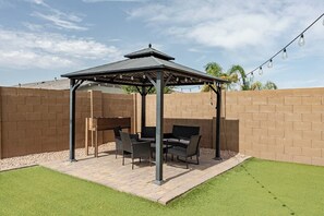 A patio with a pergola, outdoor furniture, and a string of lights. - Luxurious Arizona Retreat (Queen Creek)