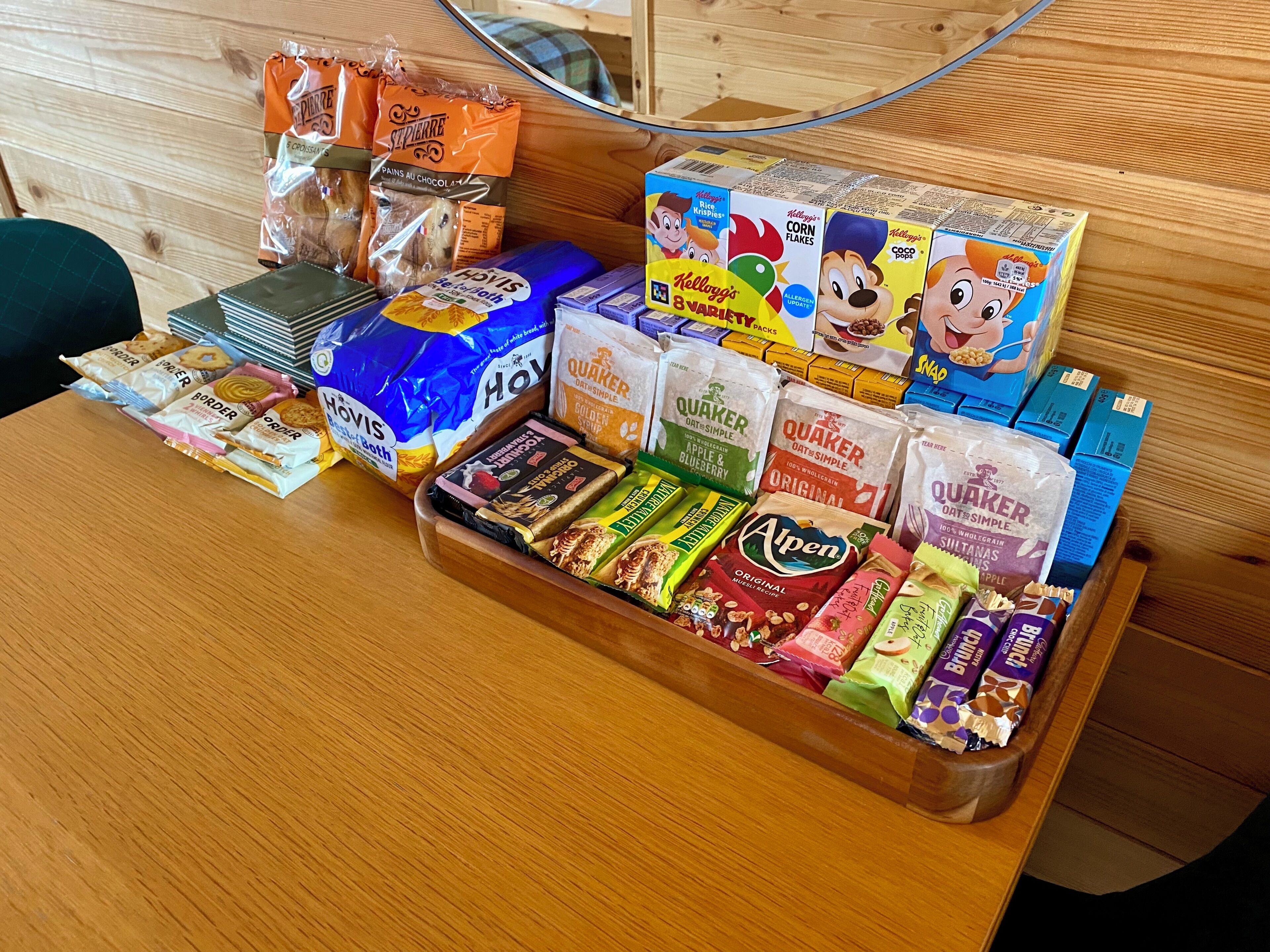 A variety of packaged food items on a wooden table.