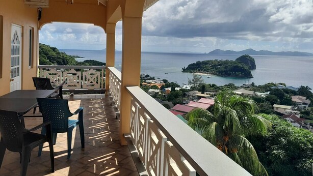 Un balcone con vista sul mare e una piccola isola.