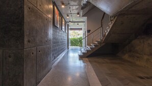 A modern interior with a concrete wall, a polished floor, and a staircase leading to an outdoor area. - Emerald 215 - Studio With Balcony and Shared Pool (Patong)
