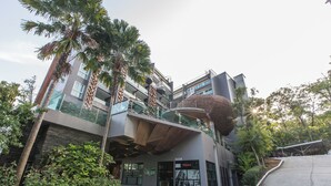 A modern building with a unique architectural design, featuring a curved structure and multiple balconies. - Emerald 215 - Studio With Balcony and Shared Pool (Patong)