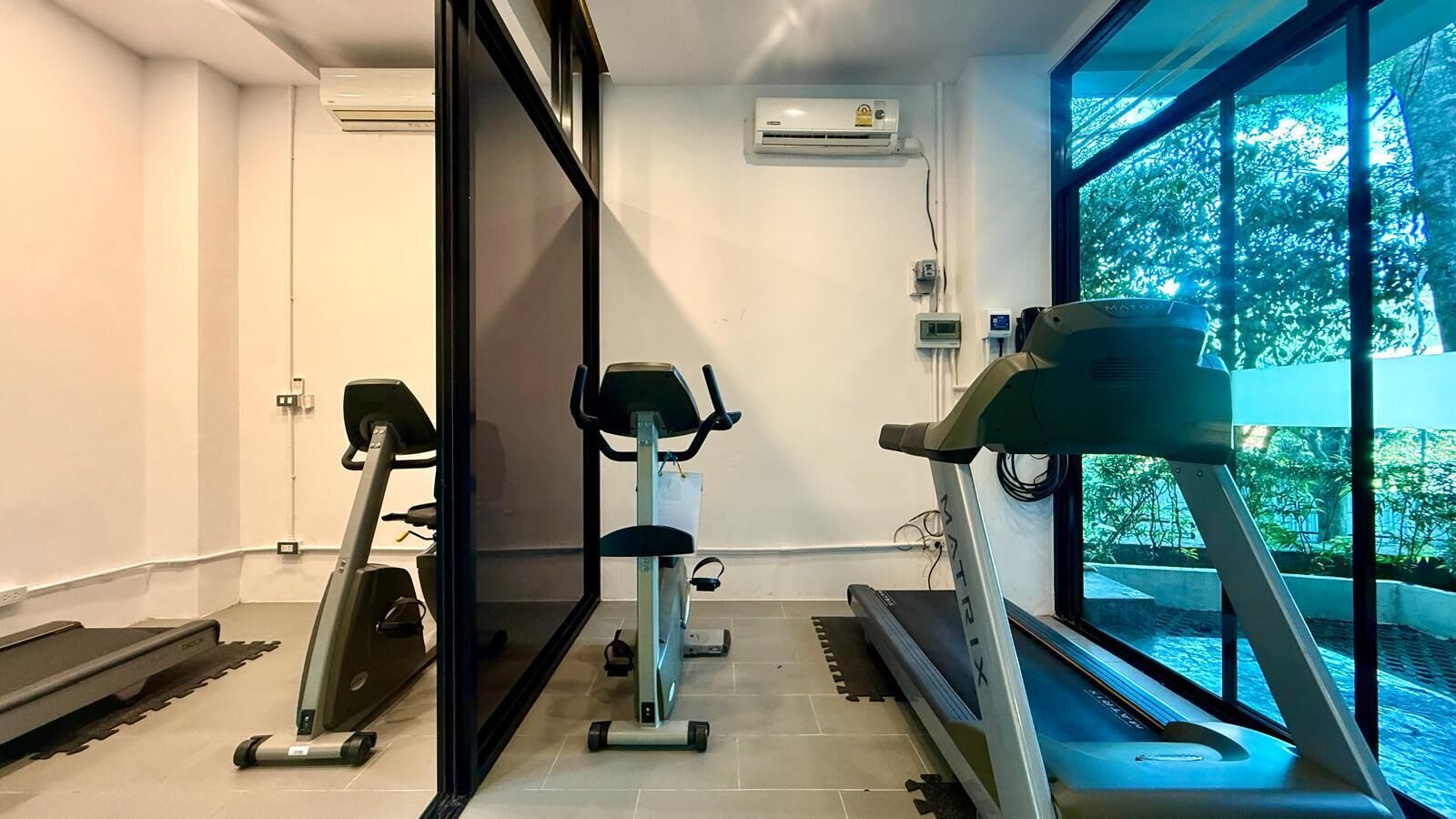 A gym with treadmills, a stationary bike, and a rowing machine.