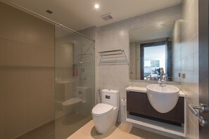 A modern bathroom with a glass shower enclosure, a toilet, a sink, and a mirror. - Emerald 702 - Triplex Penthouse With Stunning View (Patong)