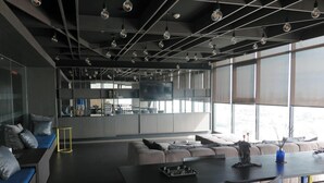 Ein modernes Interieur mit Essbereich, Sofas und einer durch große Fenster einsehbarer Küche.